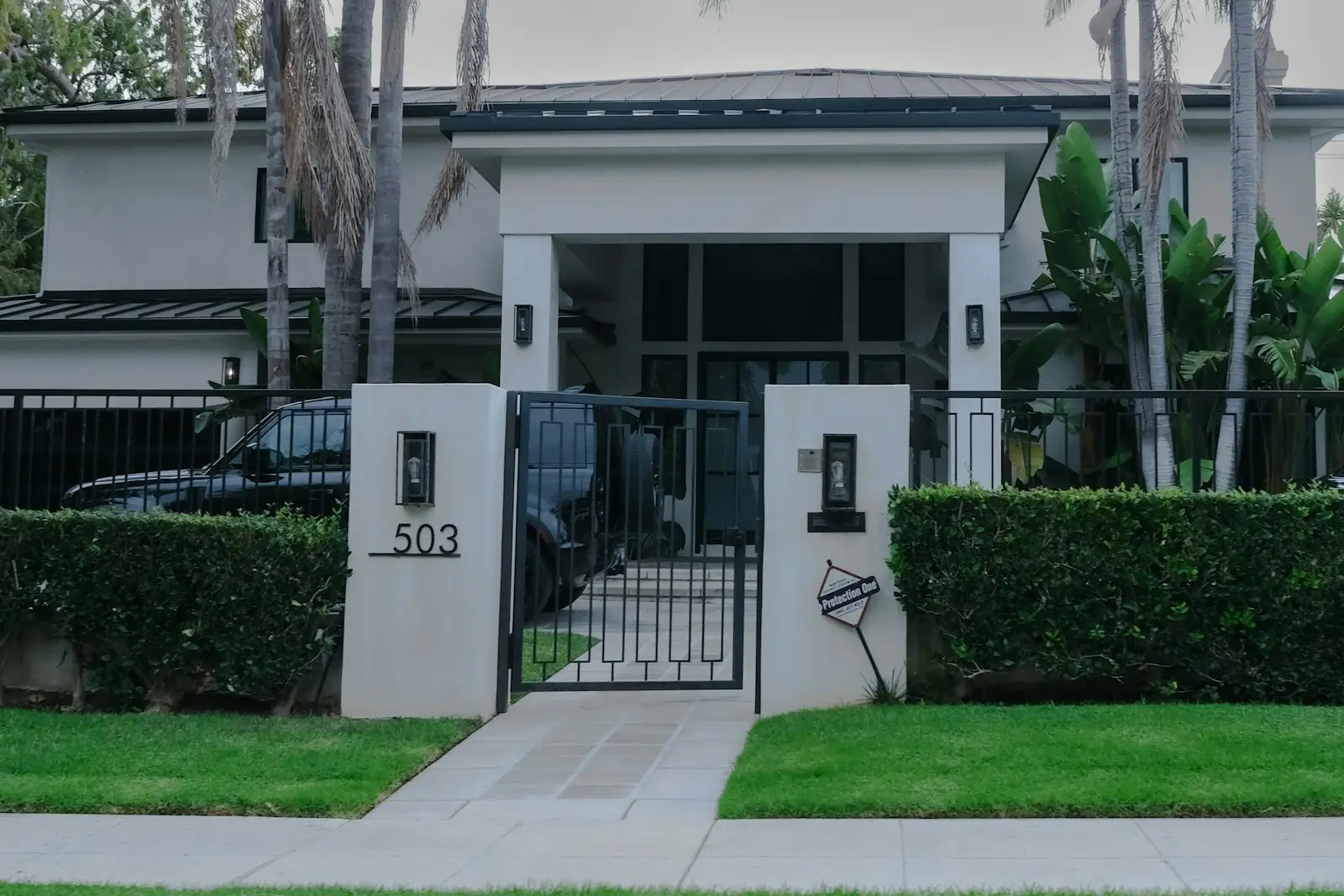 Modern home entry with trimmed hedges and lawn